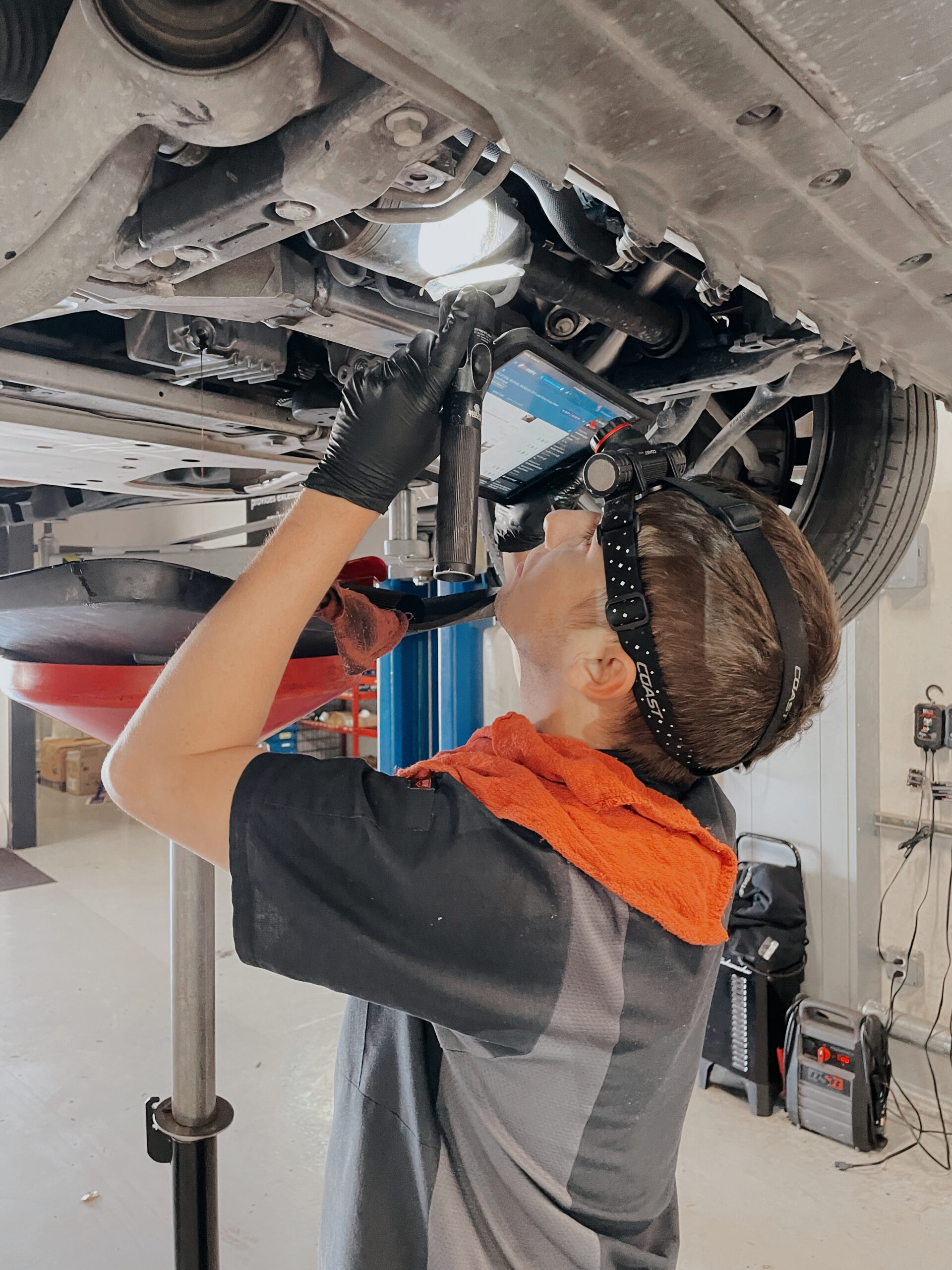 Auto Tech Performing Spring Maintenance Service on a Vehicle.