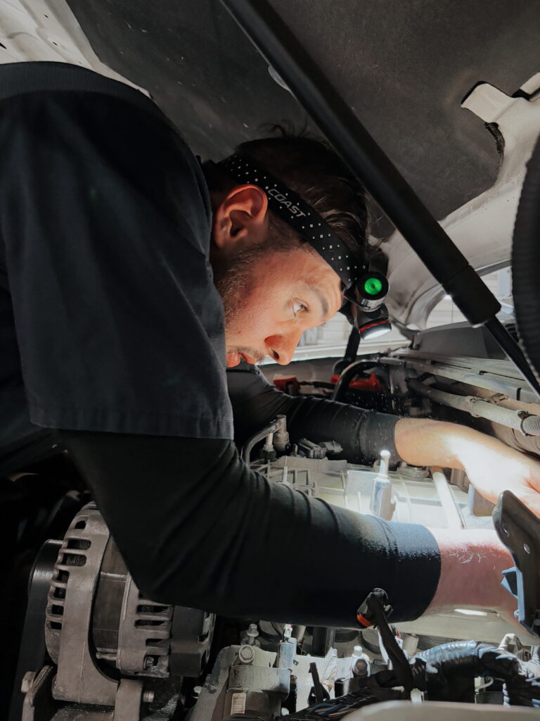 Auto Tech performing fluid top off on a vehicle